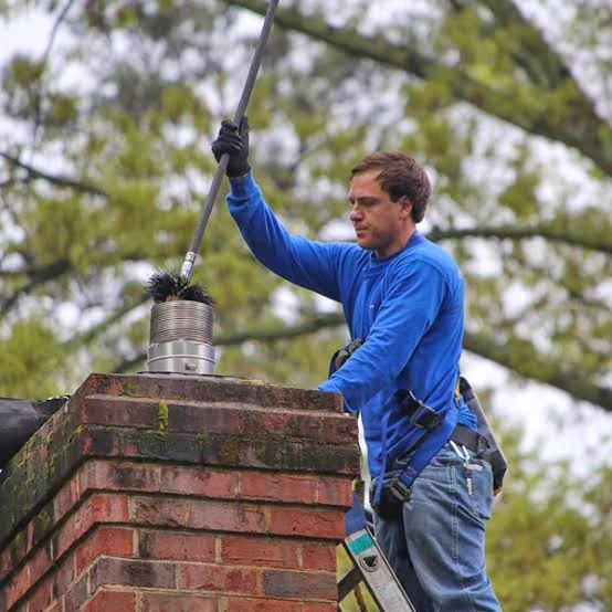 A chimney brush being lowered into a stainless-steel flue liner